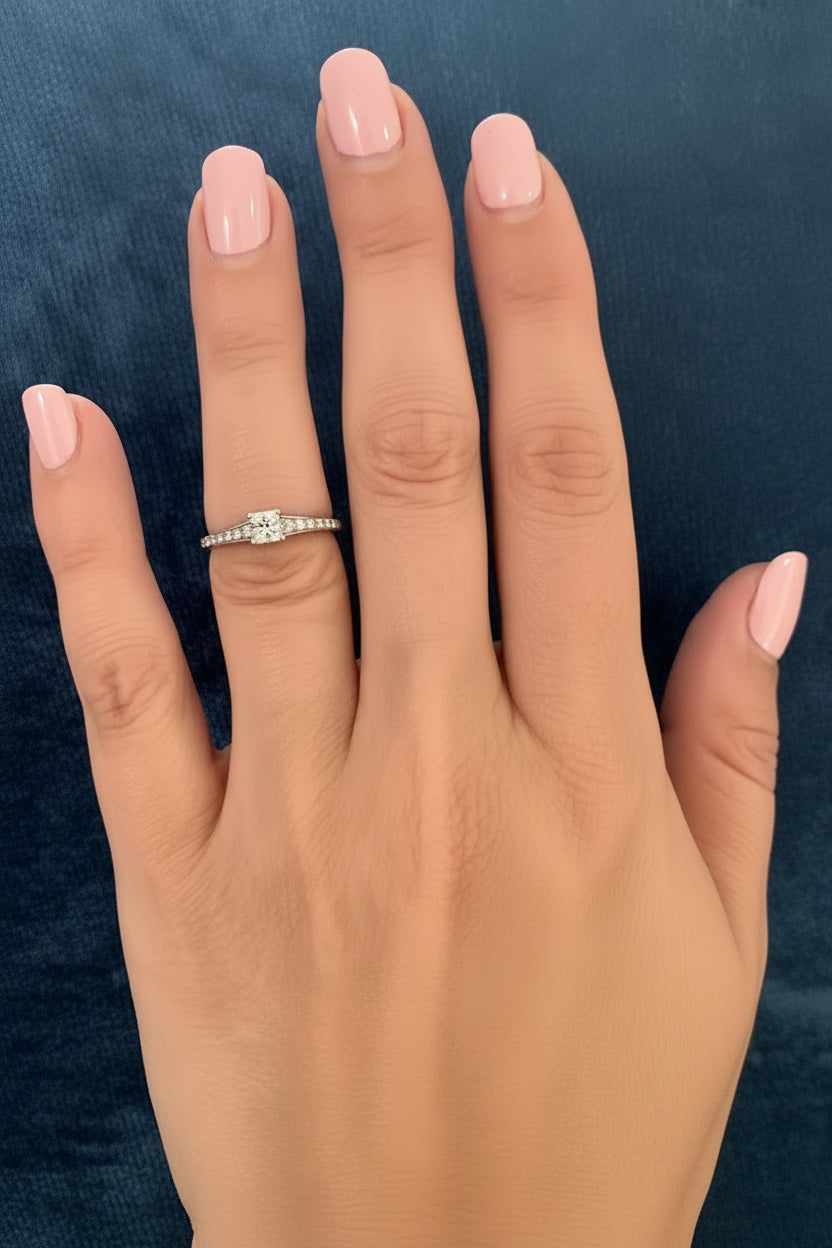 Hand wearing a diamond ring on a blue textured background canadian maple leaf diamond princess cut canadian diamond - ethically sourced from Ekati mine in Canada