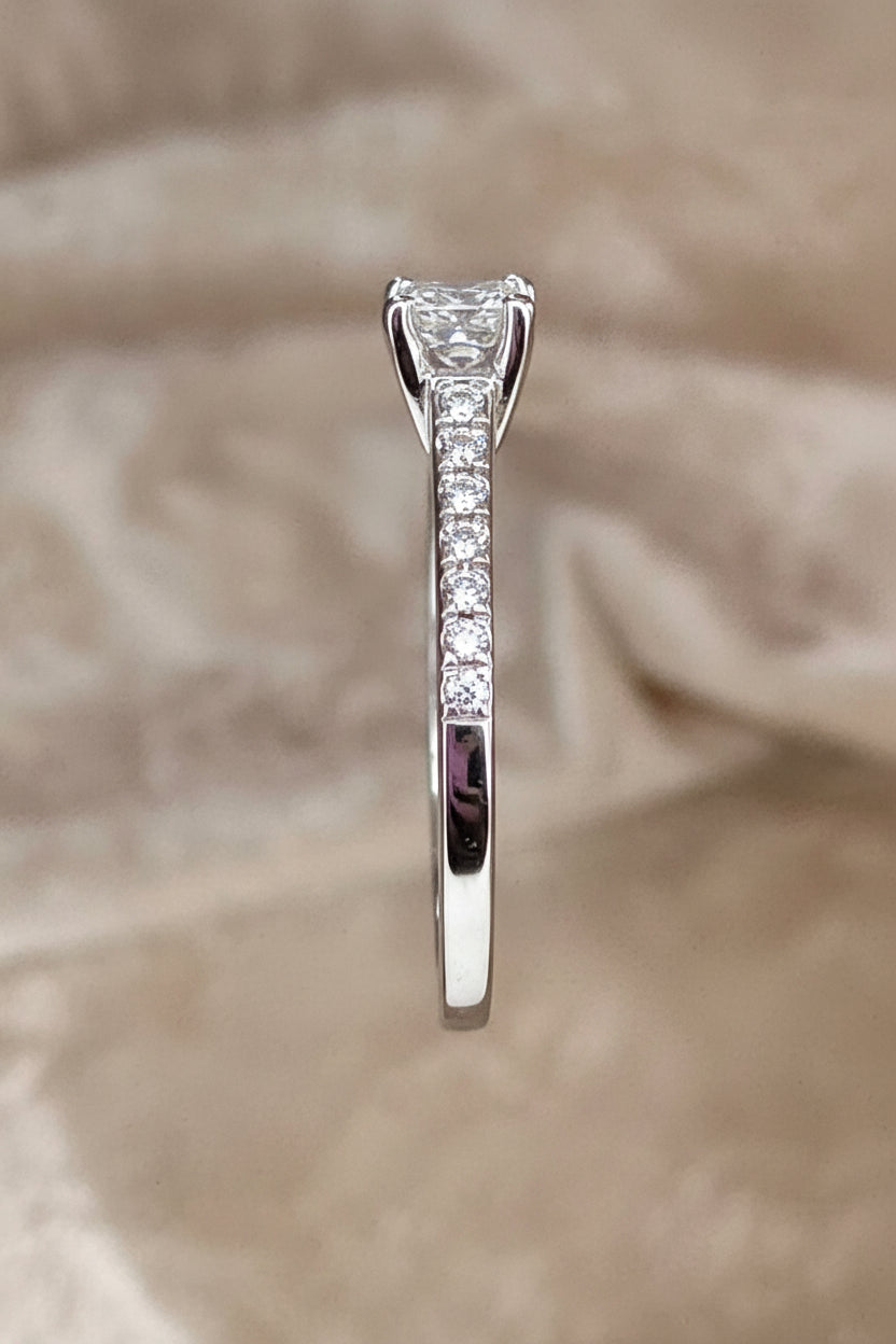 white gold ring with a diamond on a beige background