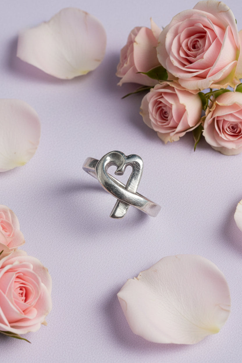 Silver heart ring on a lilac background with roses