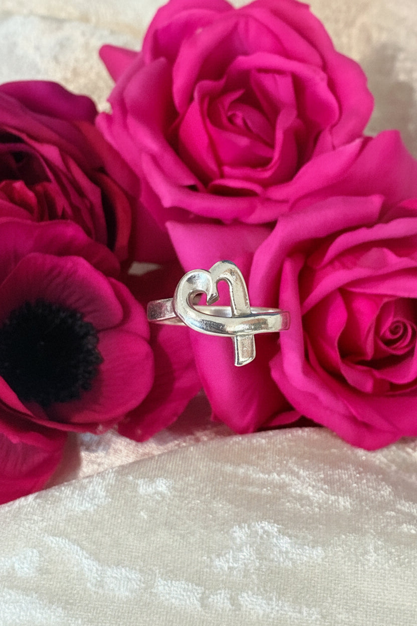 Silver heart-shaped ring on a pink floral background authentic Paloma icasso Tiffany  Co. Loving Heart Ring