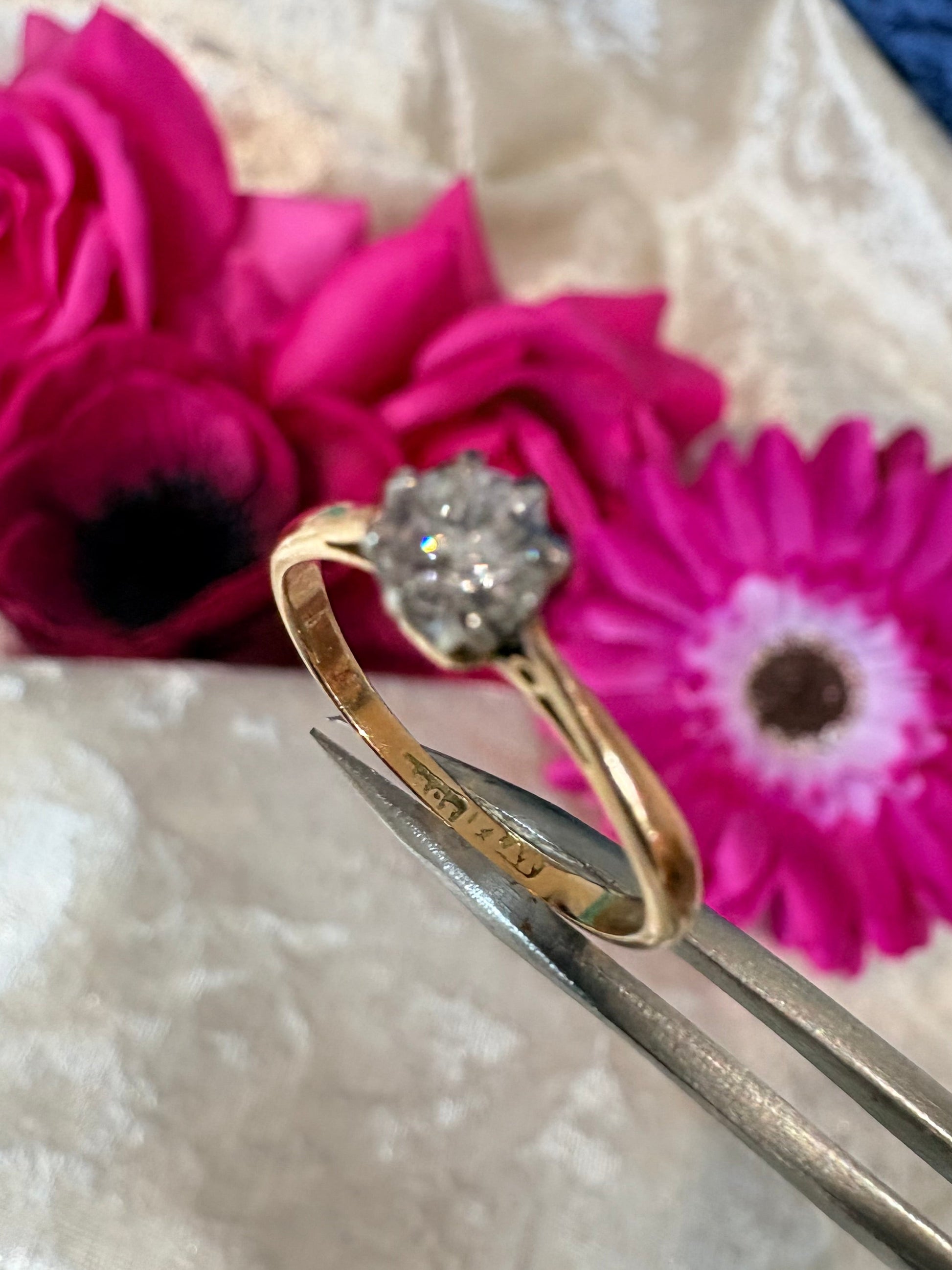 Gold ring with diamond on pink flowers showing a stamp saying '18ct' and 'PLAT'