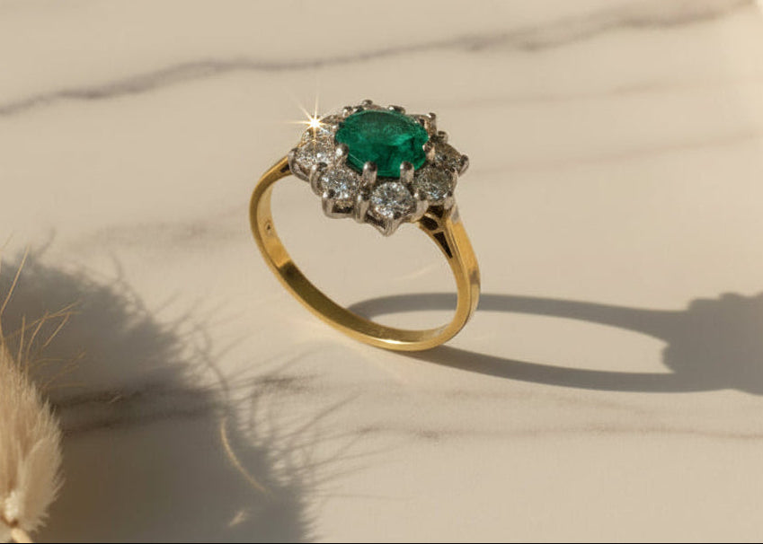 Gold ring with a green gemstone on a textured surface