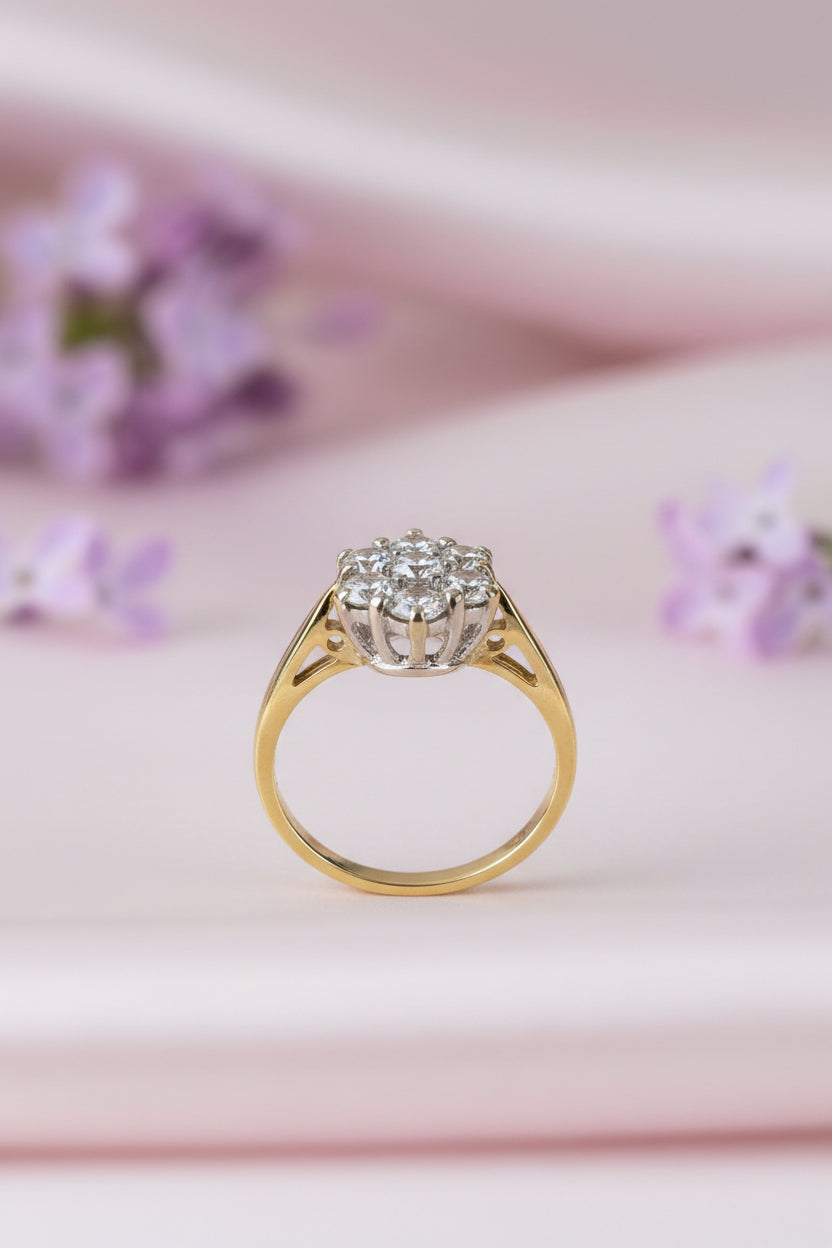 Gold ring with a diamond on a pink background with flowers