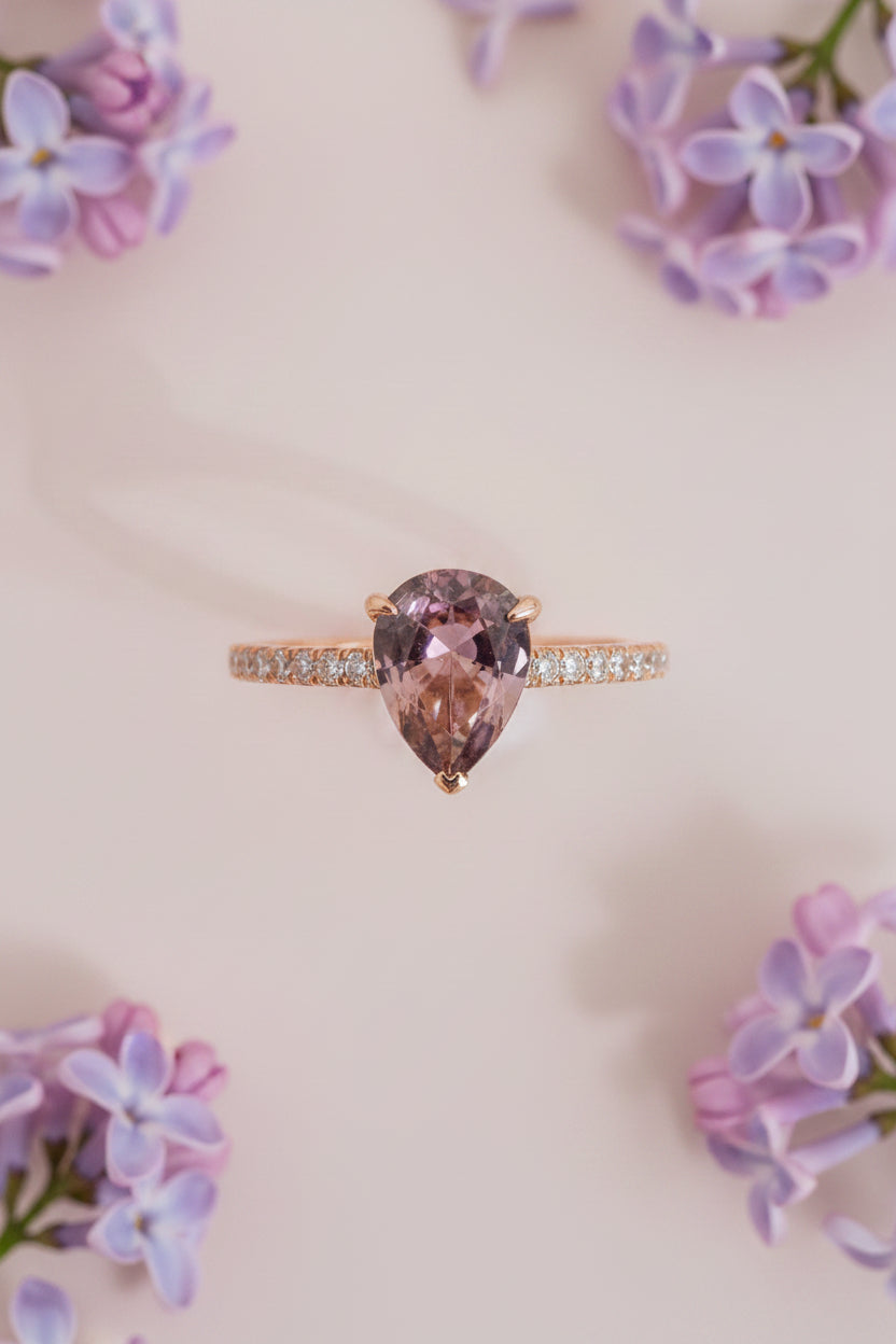 Ring with a brown sapphire and diamond accents on a light pink background