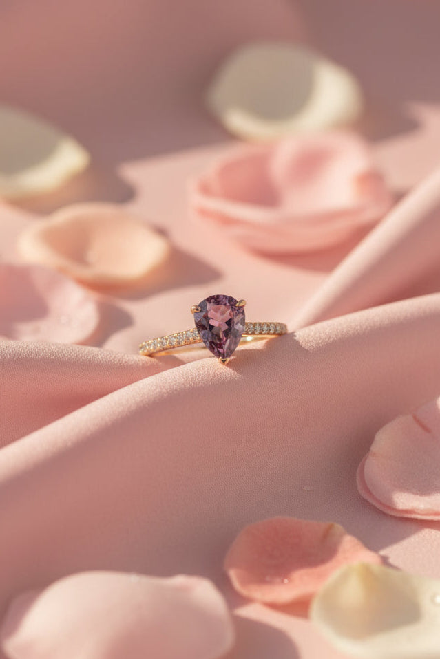 Gold ring with a brown sapphire on rippled pink fabric