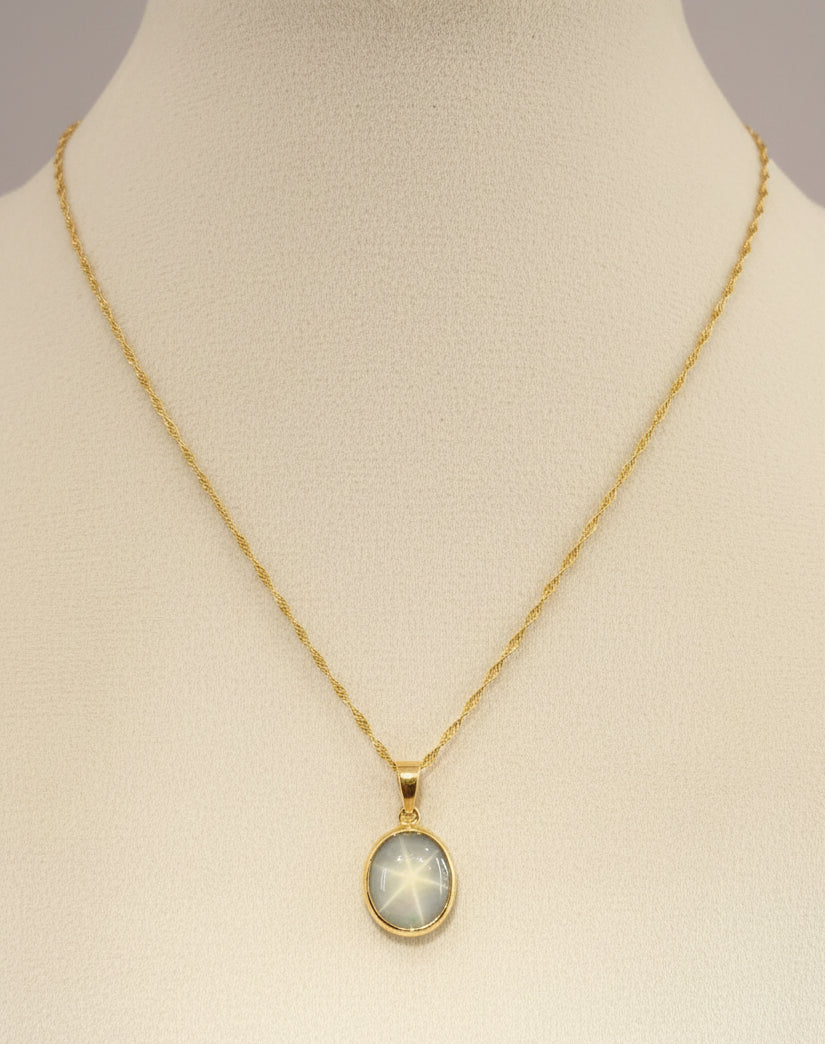 18ct yellow gold Necklace with a star sapphire pendant on a mannequin bust against a cream background