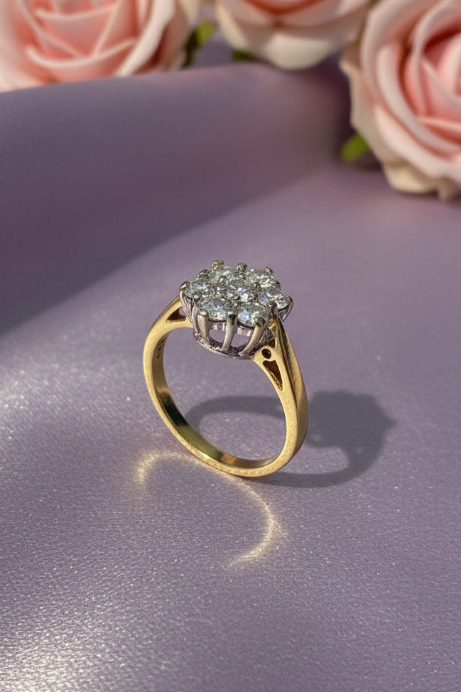 Gold ring with a daisy diamond on a white surface