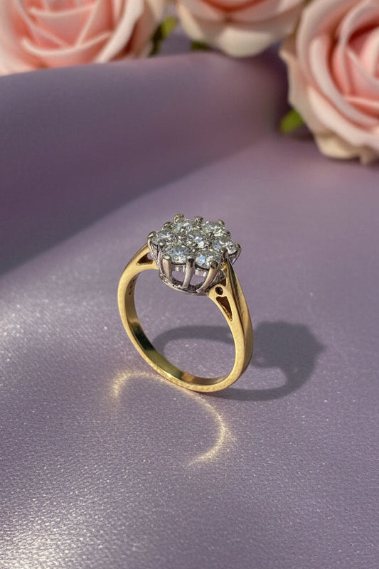 Gold ring with a daisy diamond on a white surface